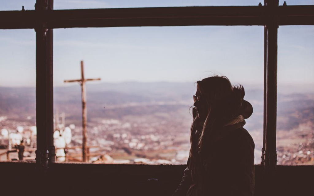 a woman looking at a cross, a true Christian