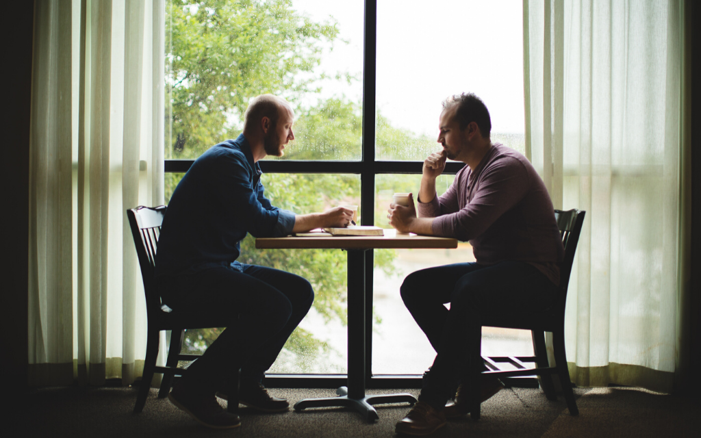 Two men sitting at a table, apologetics