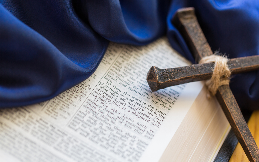 A bible with a cloth and cross on it