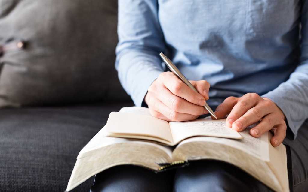A person sitting on a couch doing Scripture Writing